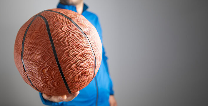 Caucasian man holding basketball ball.