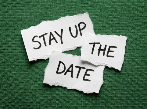 Torn paper with "STAY UP THE DATE" handwritten message on textured green background, representing timeliness and current information.