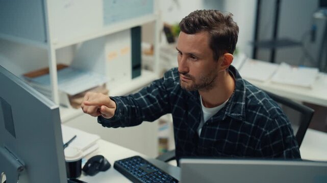 Young Caucasian male programmer writes code using multiple screens in home office workspace. AI development, cybersecurity, network database system, software engineering, remote tech startup concept.