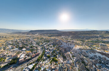 Fototapeta premium Goreme, Nevsehir, Turkey. Wide panoramic aerial view of Goreme town focusing on the intricate pattern of streets, buildings, and cave dwellings in the late morning light. Aerial view.