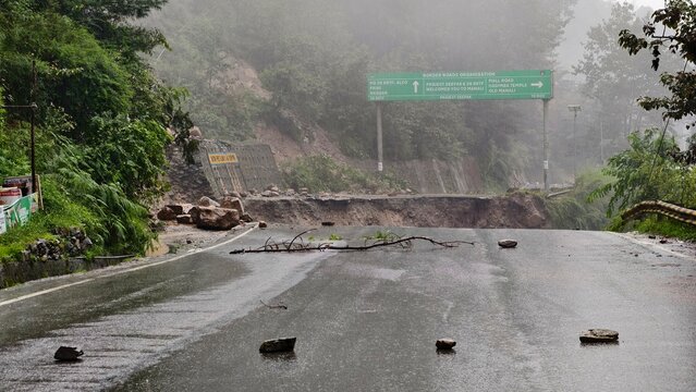 Mountain road damaged by floodwaters near Manali, Himachal Pradesh, surrounded by rugged Himalayan slopes under dramatic skies, illustrating the powerful forces of nature. Photo taken in August 2025.