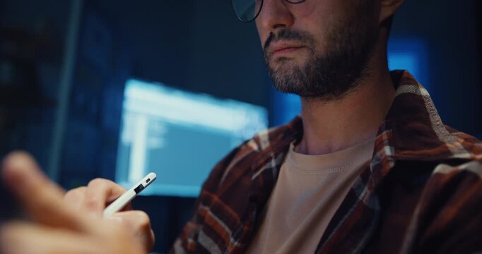 Young Caucasian male programmer use tablet for code design and plan in dark home office at night. AI technology, cybersecurity, software developer, freelance innovation, digital data network concept.