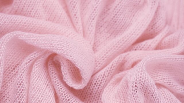 Soft Wool knitted mohair background. Light pink Alpaca wool clothes texture closeup. Cashmere Soft and fluffy merino wool macro shot. Top view woolen fabric backdrop. Rotating. 
