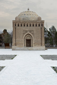 Ismail Samani Mausoleum in Bukhara featuring intricate brickwork and a large dome under overcast skies. Historic Uzbekistan landmark ideal for travel publications and cultural heritage projects.