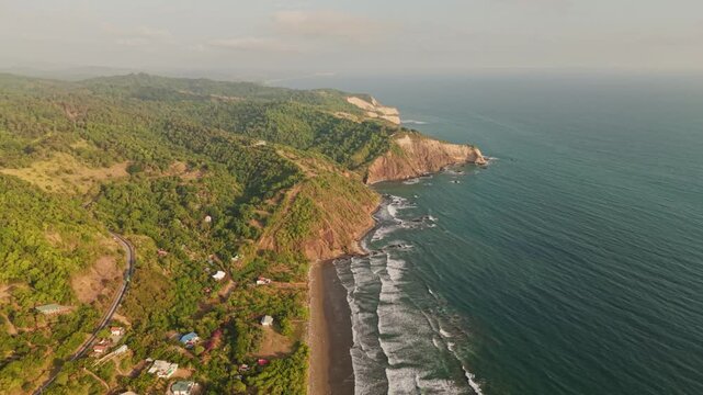 Lush green hills meeting the beautiful sandy beach and turquoise ocean waters in olon, ecuador