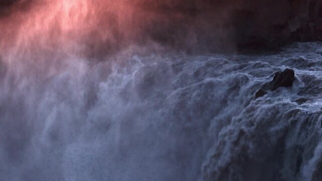 Aldeyjarfoss waterfall thundering over basalt columns bathed in warm golden light, Iceland