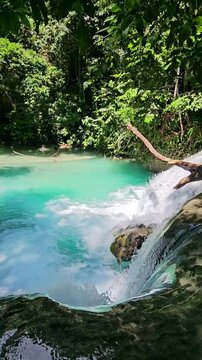 Cascade waterfall with turquoise water in natural pool. Luwuk, Indonesia