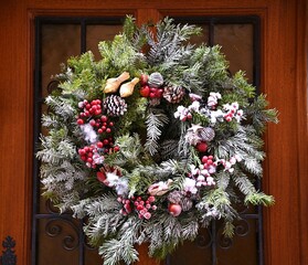 Festive Christmas wreath on an antique oak wooden door in Saint-Hippolyte, Alsace France. © ELENI MAVRANDONI