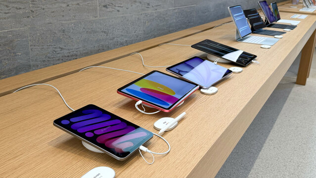 05.05.2026 - Berlin, Germany. Display of multiple Apple tablet devices on a wooden table in a retail store