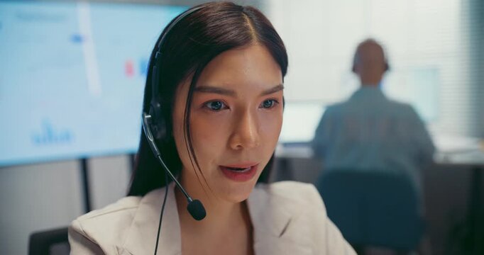 Young Asian female agent talking on phone headset consulting client online in call center office. Corporate customer service, technical support, remote tech operator, business team help desk concept.