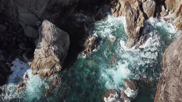 Overhead view of waves rushing between jagged lava rocks background plate for coastal edits, Flores