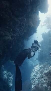Man freediver swims in a deep canyon in the blue ocean, Menjangan island