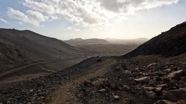 Fagradalsfjall volcanic valley at sunset, cinder cones and lava ridges backlit against golden sky, Reykjanes