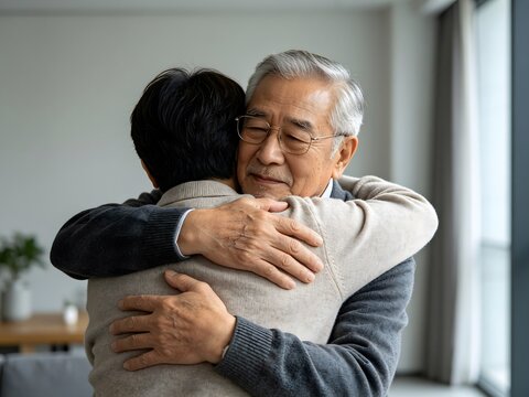 Emotional embrace between senior father and adult son at home