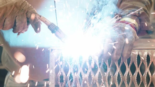 Industrial Worker Welding Metal Mesh with Bright Sparks