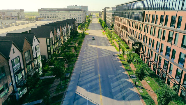 Focused view highlights central roadway connecting diverse building types within master planned development. Consistent structural heights illustrate density management goals in Coppell, TX