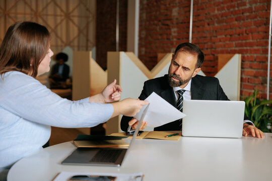 Businesswoman reviewing document with male colleague in meeting