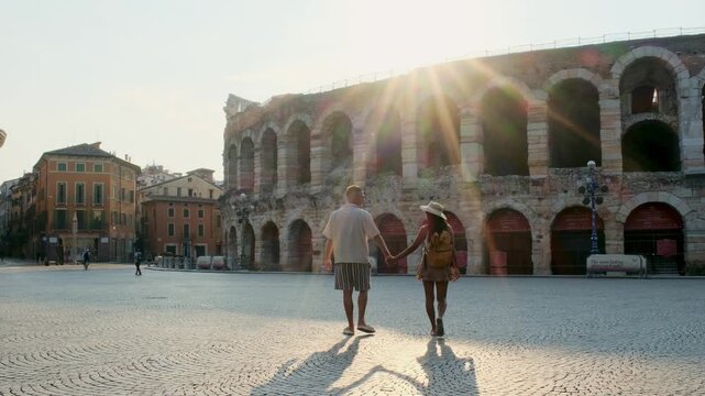 Verona Italy offers a romantic stroll through its historic streets. A couple walks hand in hand near the iconic Arena, basking in the warm glow of the setting sun.