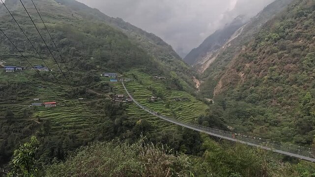 Jhinu Danda suspension bridge spans the valley above terraced fields, the longest in Kaski, Annapurna Base Camp trek, Nepal