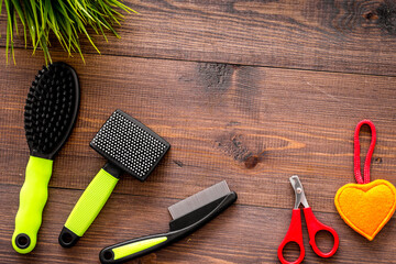 Obraz premium grooming tools for training pet and brushes on wooden background top view mock-up
