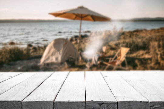 Beach camping scene on a sandy tropical shoreline under a bright blue sky. Copy space for product placement or advertising text with relaxing outdoor summer atmosphere.