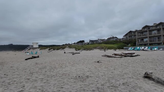 4K smooth stabilized footage of empty Adirondack chairs on Cannon Beach after Independence Day celebrations with Haystack Rock, Pacific Ocean and cloudy summer sunrise in Oregon, USA