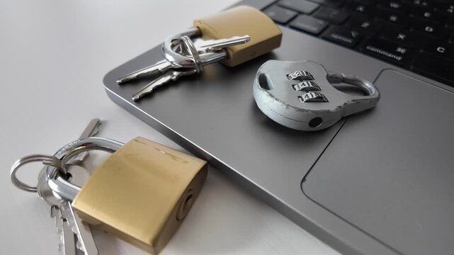 Two Padlocks on Laptop Keyboard With Keys
