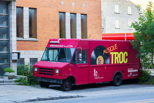 Quebec City, Quebec, Canada, July 12, 2026 - The red truck of Musique Troc - a mobile unit based in the city and presenting musical shows and interactive events - parked on street