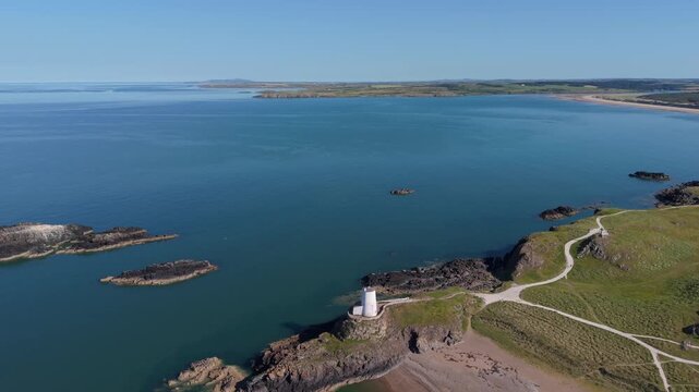 Drone footage circling and rising right to left at Llanddwynn lighthouse Anglesey