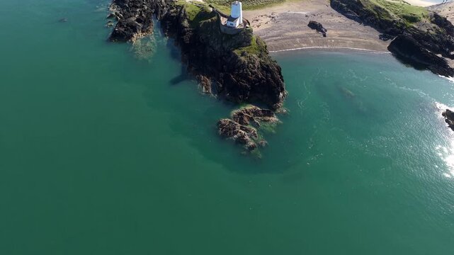 Upward seeping reveal of LLanddwynn lighthouse in Wales