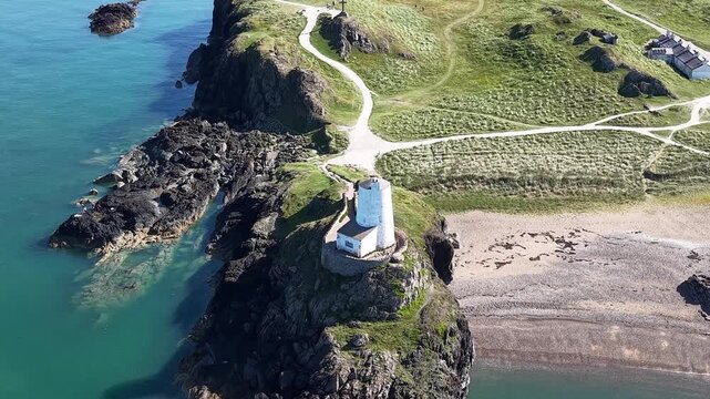 Telephoto far away circle from high drone looking at Llandwynn lighthouse in anglesey.