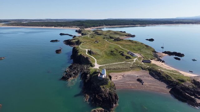 High circling drone shot over llanddwynn lighthouse Wales