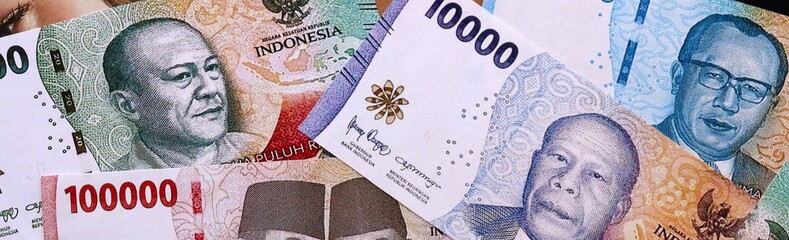 Indonesian rupiah money bills pile on table. Indonesia banknotes of IDR currency close up. © Larysa