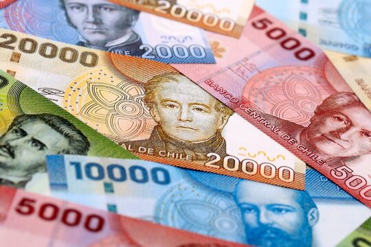 Chilean peso money bills pile on table. Chile banknotes of CLP currency close up.
