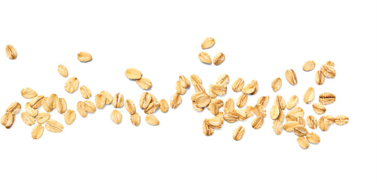 Scattered oat flakes on a clean white background.  Top view of oat flakes isolated.