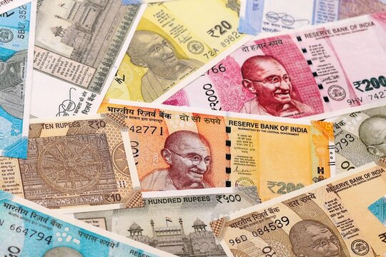 Indian rupee money bills pile on table. India banknotes of INR currency close up.