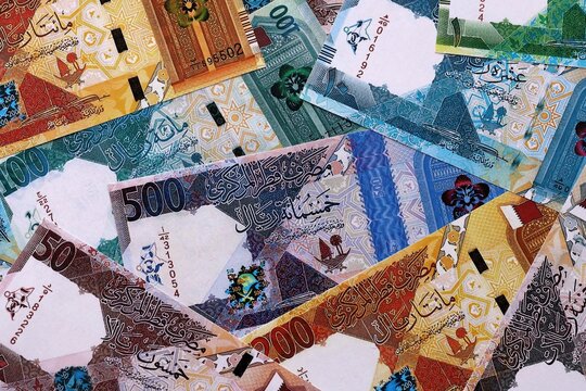 Qatari riyal money bills pile on table. Qatar banknotes of QAR currency close up.