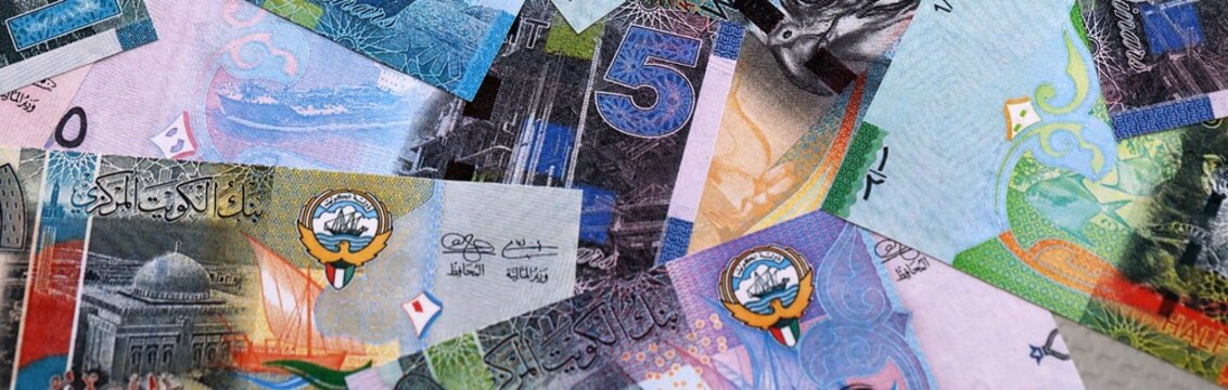 Kuwaiti dinar money bills pile on table. Kuwait banknotes of KWD currency close up.
