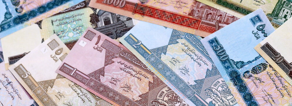 Afghan afghani money bills pile on table. Afghanistan banknotes of AFN currency close up.