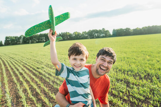 Joyful father and son launch a toy plane in the park