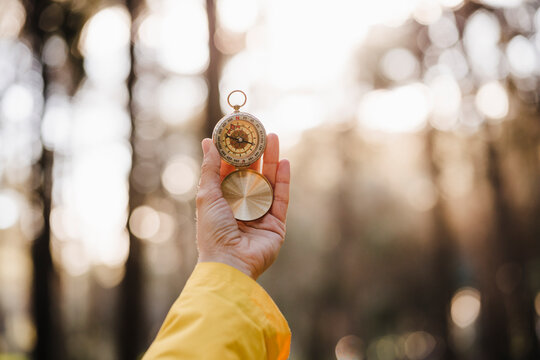 Woman holding compass in forest
