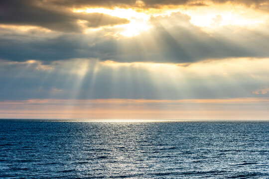Germany, Schleswig-Holstein, Sun piercing through clouds over North Sea