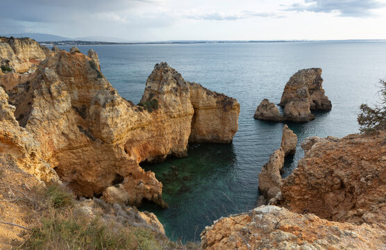 Portugal, Faro District, Lagos, Coastal cliffs at dawn with clear line of horizon over Atlantic Ocean in background