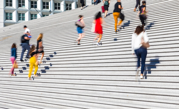 Business people climbing staircase during rush hour, Paris, France