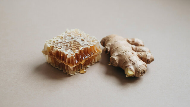 A piece of natural honeycomb with dripping honey next to a fresh ginger root on a neutral ad social media download product banner template event festive festival 2026 2027 2028