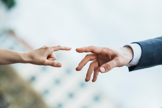 Hands of man and woman about to touch