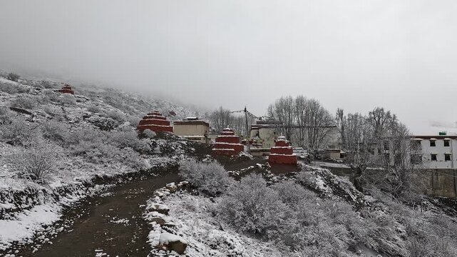 Snowy Monastery with red chortens at Lo Gekar (Ghar Gompa) hillside, Upper Mustang, Nepal