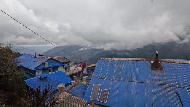 Blue tin roofed lodges below cloud covered forested ridges, Ghorepani, Nepal