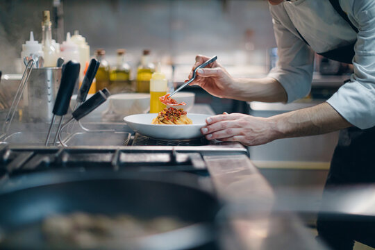 Chef preparing a dish in traditional Italian restaurant kitchen