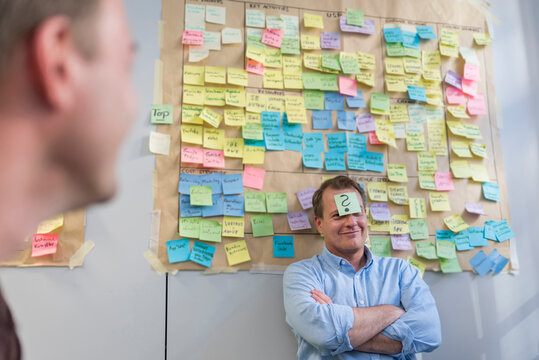 Businessman with sticky note sticking at his forehead in office